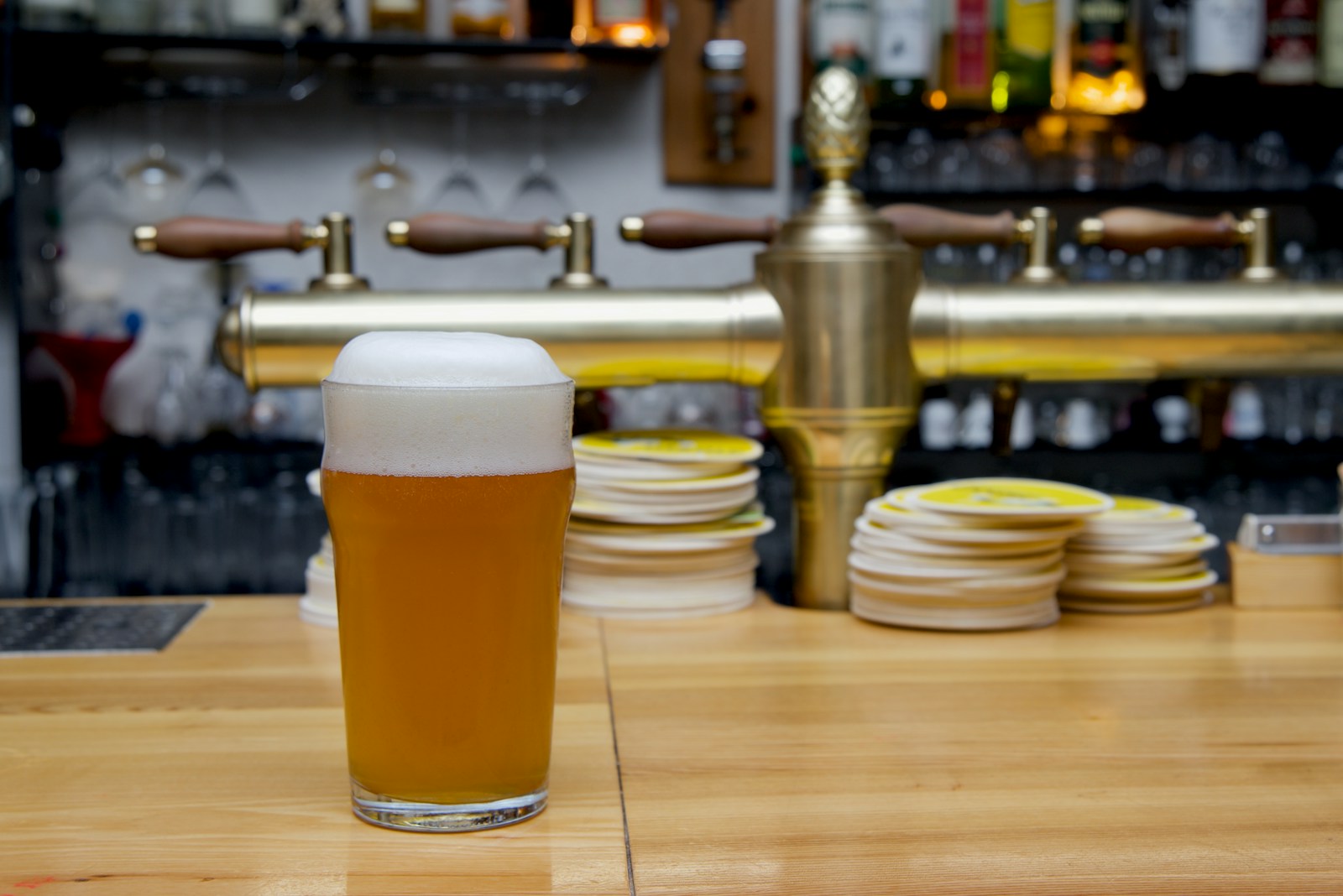 Un verre de bière posé sur une table en bois.
