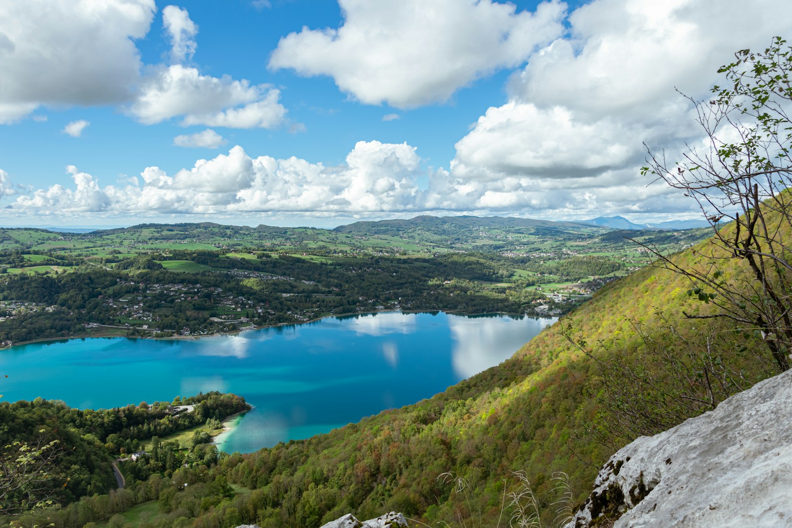 Un lac entouré de collines et d'arbres.